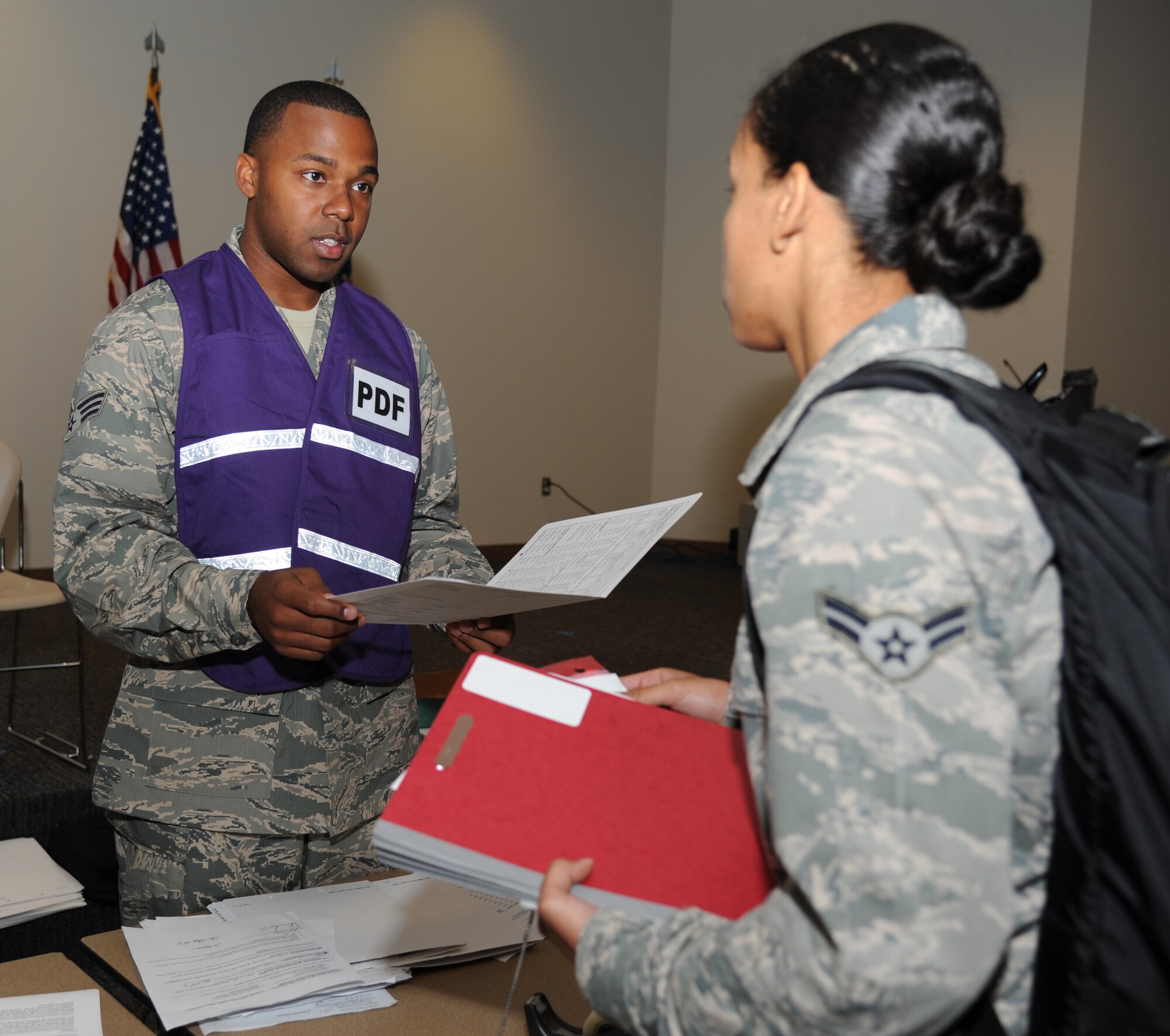 Senior Airman Terrance Hill, 81st Aerospace Medicine Squadron, reviews medical eligibility for Airman 1st Class Arianna Whitted-Lessey, 81st Diagnostic and Therapeutics Squadron, at the Roberts Consolidated Aircraft Maintenance facility Aug. 22, 2012, during a two-day deployment exercise at Keesler Air Force Base, Miss.  (U.S. Air Force photo by Kemberly Groue)