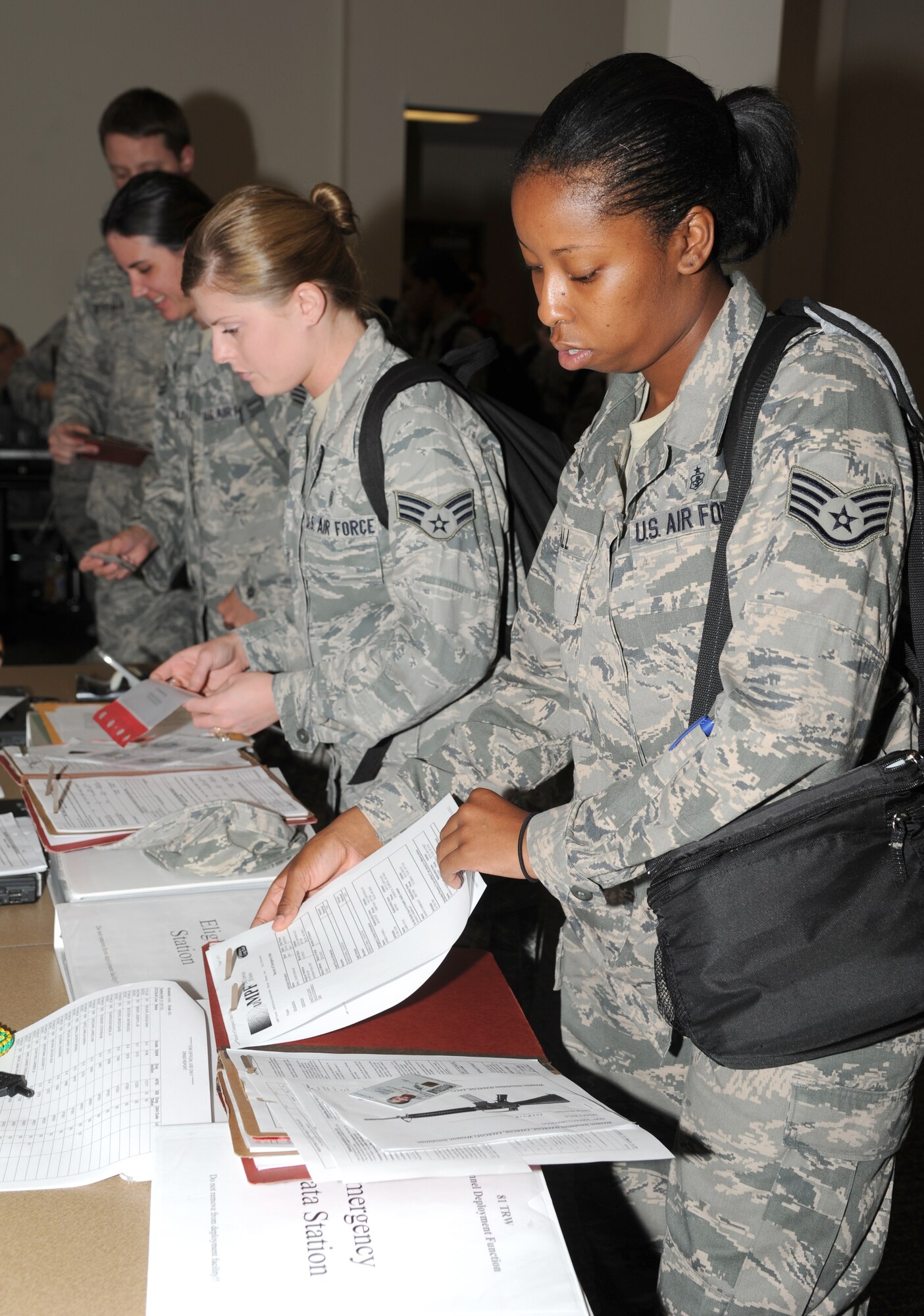 Senior Airman Mandy Polen and Staff Sgt. Shonte Small, 81st Diagnostic and Therapeutics Squadron, process through the deployment eligibility table at the Roberts Consolidated Aircraft Maintenance facility Aug. 22, 2012, during a two-day deployment exercise at Keesler Air Force Base, Miss.  (U.S. Air Force photo by Kemberly Groue)