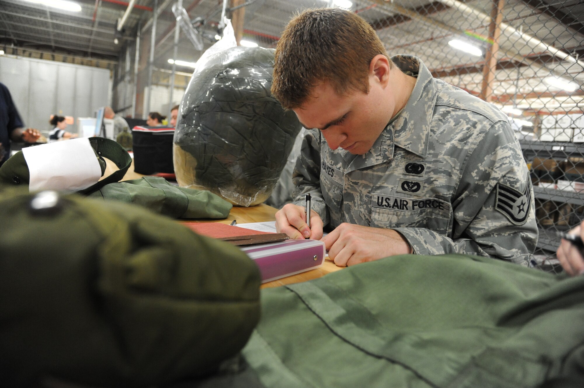 Staff Sgt. Daniel Hayes, 81st Logistics Readiness Squadron, signs a receipt for a mobility bag at the Taylor Logistics Center during a two-day deployment exercise Aug. 21, 2012, at Keesler Air Force Base, Miss.  (U.S. Air Force photo by Kemberly Groue)