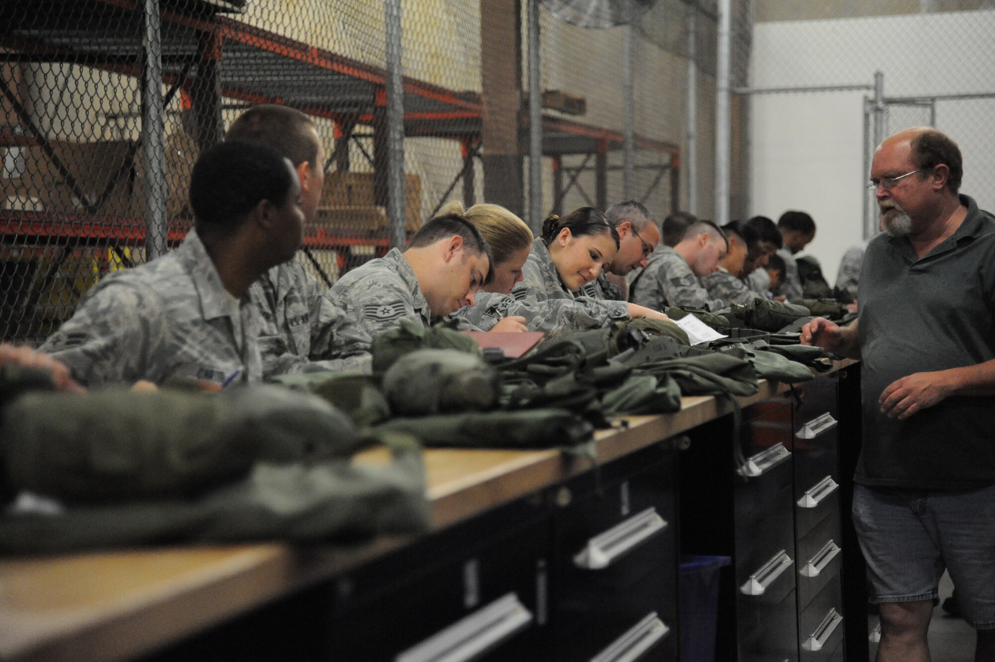 Ron Hartley, CSC, at right, issues mobility bag equipment to deploying airmen at the Taylor Logistics Center during a two-day deployment exercise Aug. 21, 2012, at Keesler Air Force Base, Miss.  (U.S. Air Force photo by Kemberly Groue)
