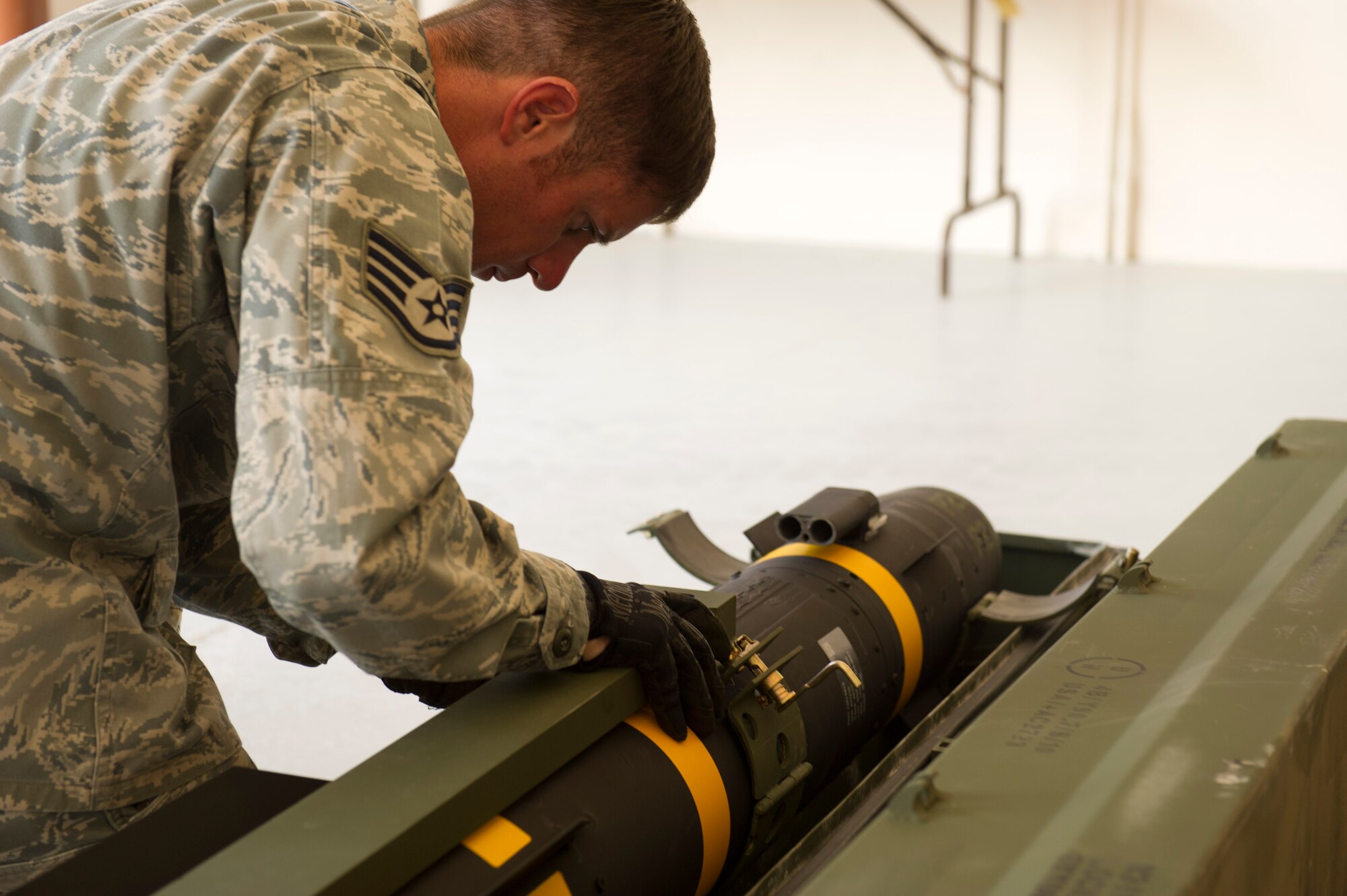 Staff Sgt. Scott Landry, 49th Maintenance Squadron precision guided munitions inspector, latches a AGM-114P Hellfire missile into a cradle for shipment at the 49th MXS Munitions Flight on Holloman Air Force Base, N.M., Aug. 22. The missiles are being sent back to their original owner’s location. The cradle ensures the utmost safety during travel. Hellfire missiles were used during a joint training exercise that occurred between the sixth and ninth of Aug., that involved the U.S. Army, Cannon AFB, N.M. and Holloman AFB. The AGM-114P Hellfire missile system is a rocket-propelled, laser-guided weapon designed to defeat individual hard point targets. (U.S. Air Force Photo by Airman 1st Class Michael Shoemaker/Released)