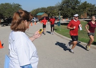 Debra Chauvin records the time of runners finishing last year's Rambler 120 Team Challenge event at Joint Base San Antonio Recreation Park at Canyon Lake. The event also includes cycling, rowing and a mystery challenge. (U.S. Air Force photo by David Terry)