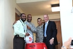 Maj. Gen. Alfred Stewart (second from left) , Air Force Personnel Center commander, joins Jacob Love, AFPC entitlements branch, Chief Master Sgt. Rubin Gonzales, AFPC command chief and Todd Fore, AFPC executive director, at a Feds Feeds Families food bank donation barrel during a collection event held at AFPC on Joint Base San Antonio-Randolph, Texas Aug. 15. (U.S. Air Force photo by Rich McFadden)