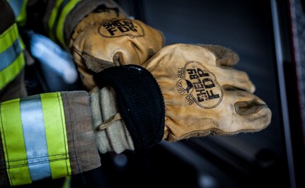 Senior Airman Erik Myles, 628th Civil Engineer Squadron firefighter, puts his gloves on during a drill Aug. 20, 2012, at Joint Base Charleston –Air Base, S.C. Each fire fighter has six pieces of equipment to put on in less than two minutes when responding to an emergency call. (U.S. Air Force photo/Senior Airman Dennis Sloan)
