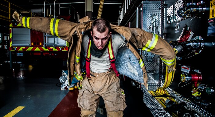 Senior Airman Erik Myles, 628th Civil Engineer Squadron firefighter, puts his fire jacket on during a practice response to an emergency call Aug. 20, 2012, at Joint Base Charleston – Air Base, S.C. Each member of the team has six pieces of equipment to put on in less than two minutes when responding to an emergency call. (U.S. Air Force photo/Senior Airman Dennis Sloan)