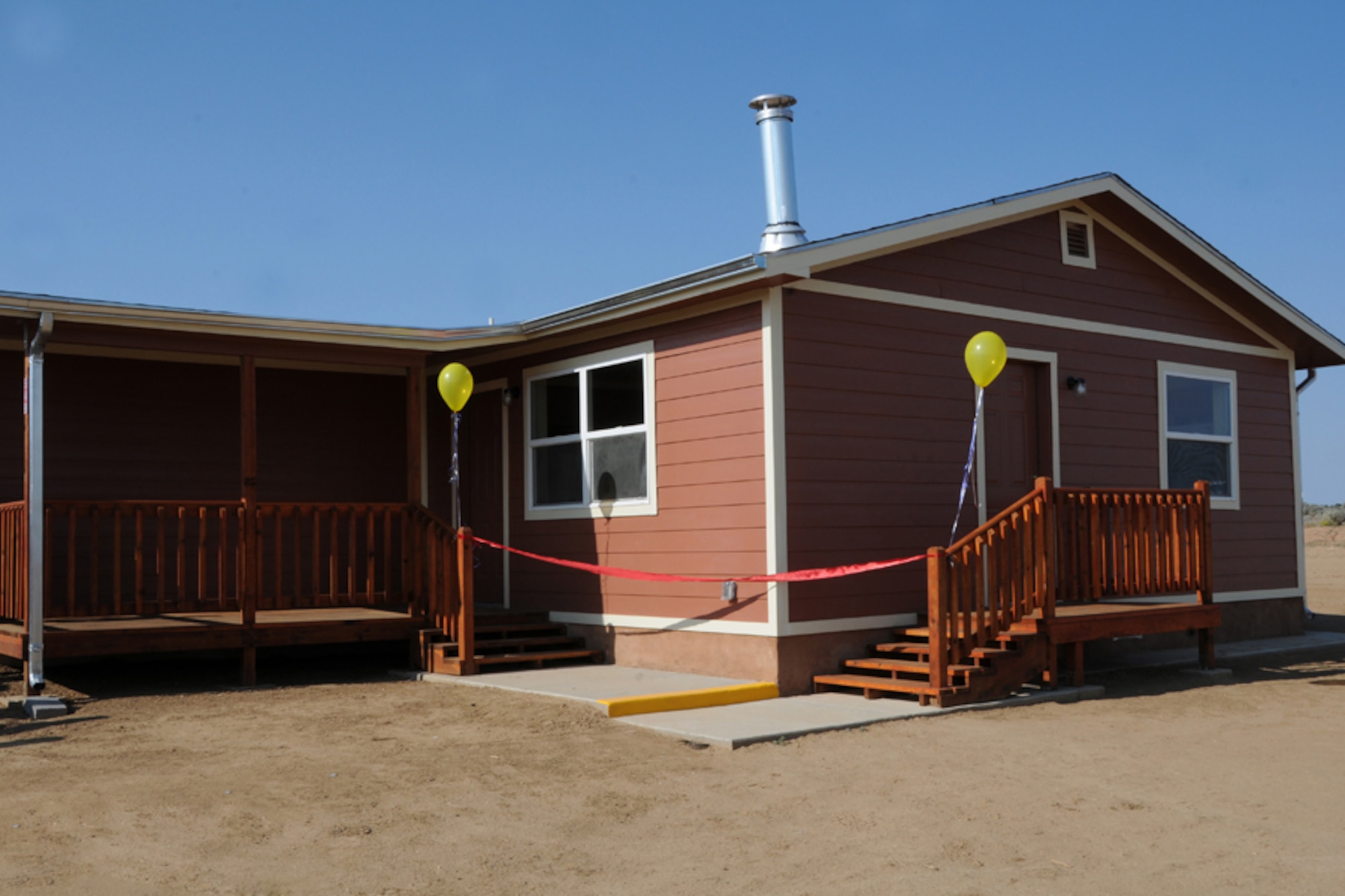Members of the military participating in the Innovative Readiness Training mission Operation Footprint partnered with other local agencies such as Veterans Administration, Southwest Indian Foundation, Navajo Housing Authority, to dedicate the 200th home built to a local Navajo family in Gallup, N.M., Aug. 16, 2012. IRT mission Operation Footprint is an Air National Guard led IRT multiservice mission comprised of active duty, reserve, and National Guard members from Army, Navy and Air Force components focusing on deployment and real-world readiness training preparing for wartime missions in a joint-service environment while simultaneously providing free civil engineering services to the community.  (National Guard photo by Tech. Sgt. Melissa E. Chatham/RELEASED)
