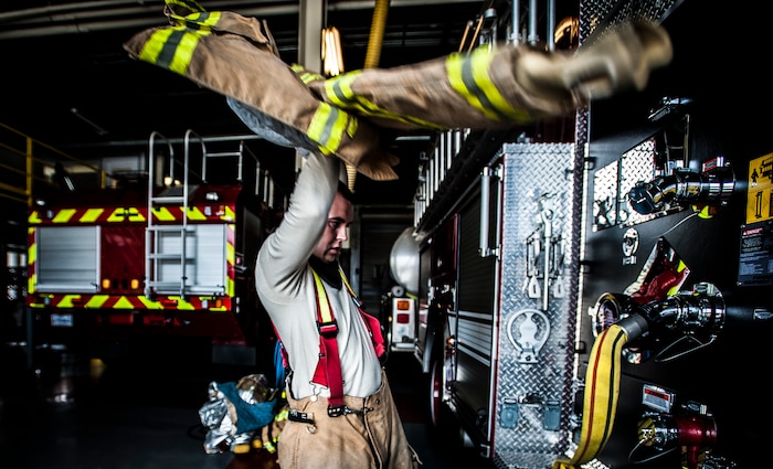 Senior Airman Erik Myles, 628th Civil Engineer Squadron firefighter, puts his fire jacket on during a drill Aug. 20, 2012, at Joint Base Charleston – Air Base, S.C. Each member of the team has six pieces of equipment to put on in less than two minutes when responding to an emergency call. (U.S. Air Force photo/Senior Airman Dennis Sloan)