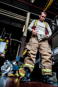 Senior Airman Erik Myles, 628th Civil Engineer Squadron fire fighter, puts his boots and pants on during a drill Aug. 20, 2012, at Joint Base Charleston – Air Base, S.C. Each firefighter has six pieces of equipment to put on in less than two minutes when responding to an emergency call. (U.S. Air Force photo/Senior Airman Dennis Sloan)