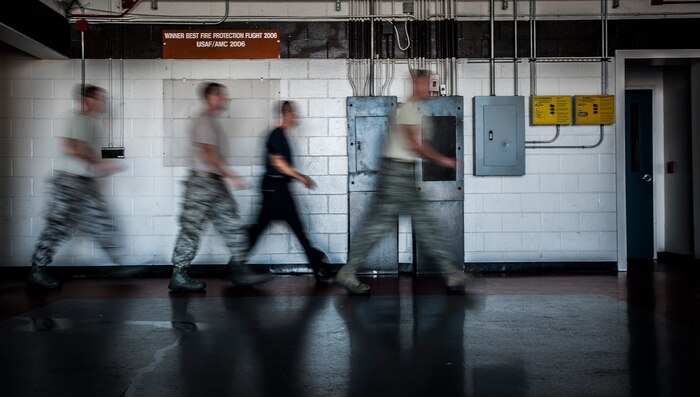 628th Civil Engineer Squadron firefighters rush to put on their gear during a drill Aug. 9, 2012, at Joint Base Charleston – Air Base, S.C. The firefighters have two minutes from notification of an emergency to don their equipment and leave the station. (U.S. Air Force photo/Senior Airman Dennis Sloan)