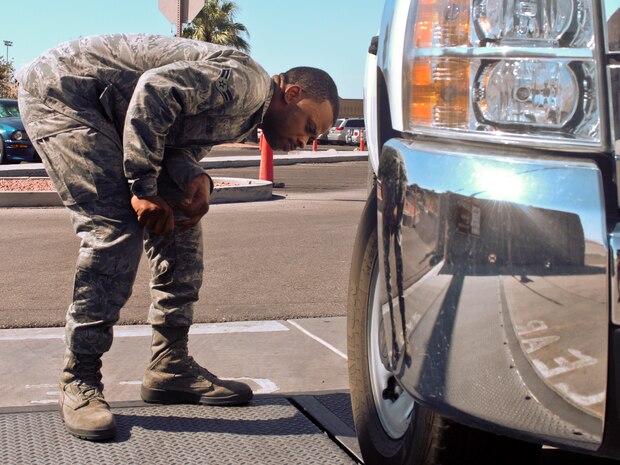 Airman 1st Class Floyd Jones Jr., 57th Operational Support Squadron airfield management specialist, performs a roll over Foreign Object Debris check Aug. 21, 2012, at Nellis Air Force Base, Nev.. FOD checks are part of training received to get a flightline drivers license. (U.S. Air Force photo by Senior Airman Jack Sanders)