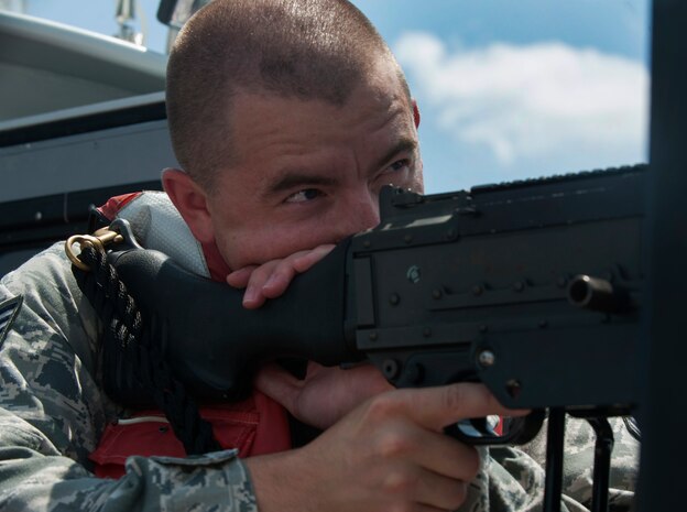 Staff Sgt. John Sweeney, 628th Security Forces Squadron Harbor Patrol Unit, demonstrates aiming an M240 machine gun while on patrol Aug. 15, 2012, at Joint Base Charleston - Weapons Station, S.C. The M240 has a weight of 27.6 lbs., a maximum effective range of 1,800 meters area target and 800 meters point target. The M240 can shoot from 200 to 600 rounds-per-minute. Officers from the Harbor Patrol Unit must be qualified on the M240 and the M60 machine gun. (U.S. Air Force photo/Airman 1st Class Ashlee Galloway)