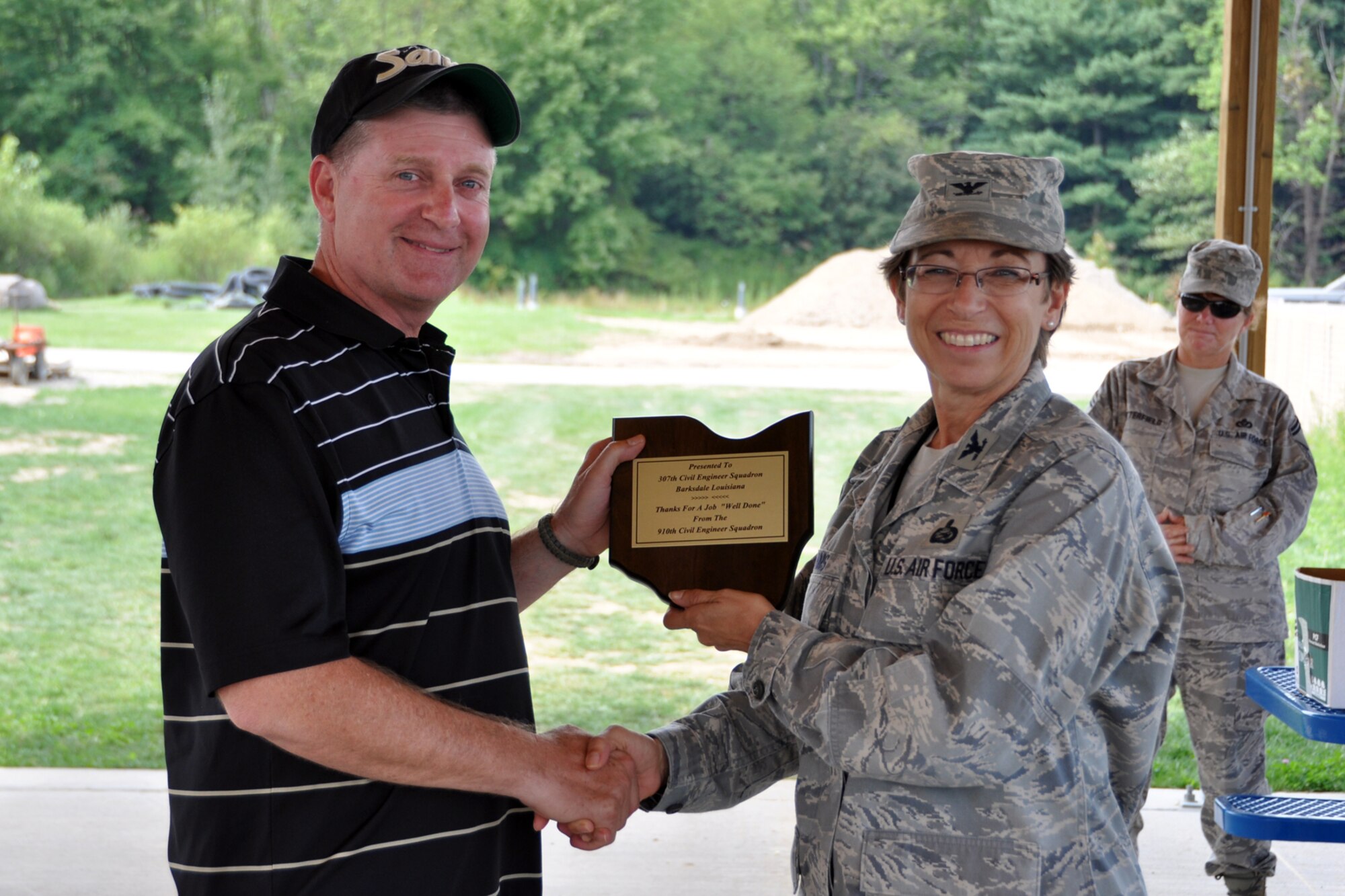 Chief Master Sgt. Randall Noble, chief of operations for the 307th Civil Engineer Squadron, accepts an appreciation plague from Col. Teresa Hams, commander of the 910th Mission Support Group, during a cookout at the Youngstown Air Reserve Station, Vienna, Ohio, Aug. 16, 2012. Noble was part of a 29-person detail from the 307 CES at Barksdale Air Force Base, La., that spent two weeks at Youngstown assisting the 910 Civil Engineer Squadron build a Prime Base Engineer Emergency Force (Prime BEEF) training area. (U.S. Air Force photo by Master Sgt. Jeff Walston) 