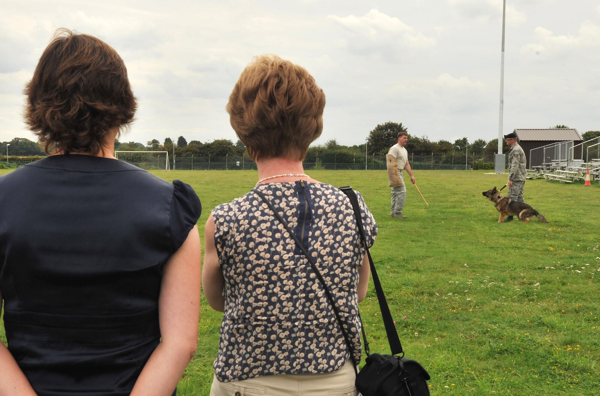 RAF MILDENHALL, England – From left, Anna Batey and Patricia Levrington watch a demonstration from the 100th Security Force’s Military Working Dogs section as part of a base tour Aug. 21, 2012, at a soccer field on base. The demonstration consisted of different search techniques and situations under which the MWD would attack a perpetrator. (U.S. Air Force photo/Senior Airman Jerilyn Quintanilla)