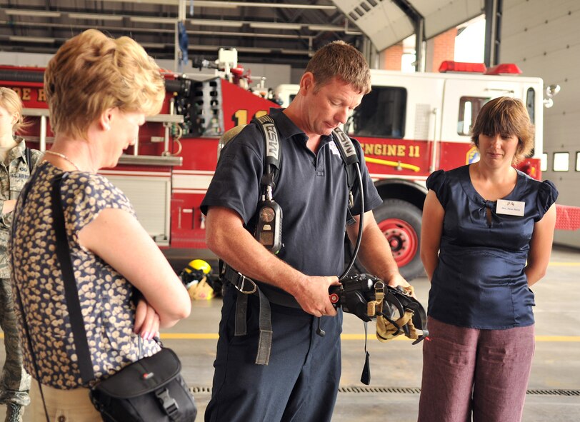 RAF MILDENHALL, England – Ian Nichols, center, 100th Civil Engineer Squadron, speaks to Patricia Levrington, worker at a local medical facility, left, and Anna Batey, school governor at Beck Row Primary School, during the British-American Committee tour Aug. 21, 2012, at the base fire department. The tour also consisted of wing mission brief, visits to the air traffic control tower, a ride in the KC-135 Stratotanker flight simulator and a tour of a static aircraft on the flightline. (U.S. Air Force photo/Senior Airman Jerilyn Quintanilla) 