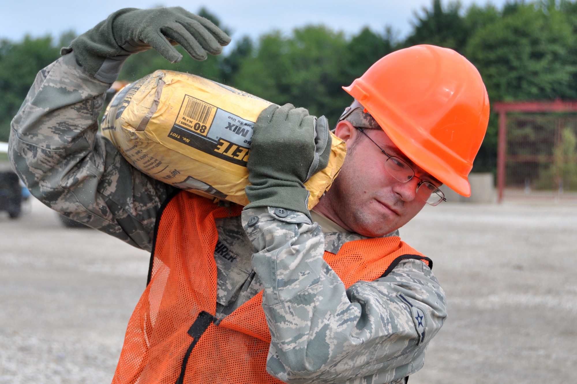 Airman 1st Class Zachary Buhrer, knowledge operations management, 307th Civil Engineer Squadron, transports a bag of cement at Youngstown Air Reserve Station, Vienna, Ohio, Aug. 14, 2012. Buhrer was part of a 29-person detail from Barksdale Air Force Base, La., that spent two weeks at Youngstown assisting the 910 Civil Engineer Squadron build a Prime Base Engineer Emergency Force (Prime BEEF) training area. (U.S. Air Force photo by Master Sgt. Jeff Walston)