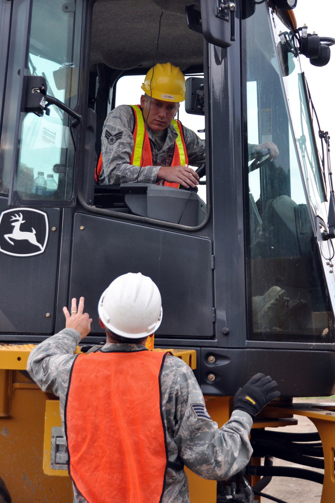 Senior Airman Bradley Morgan, a knowledge management specialist assigned to the 307th Civil Engineer Squadron from Barksdale Air Force Base, La., listens closely to directions from Staff Sgt. Case Klein, who is a heavy equipment operator for the 910th Civil Engineer Squadron at Youngstown Air Reserve Station, Vienna, Ohio, Aug. 14, 2012. Morgan was part of a 29-person detail from Barksdale that spent two weeks at Youngstown assisting the 910 CES build a Prime Base Engineer Emergency Force (Prime BEEF) training area. (U.S. Air Force photo by Master Sgt. Jeff Walston) 