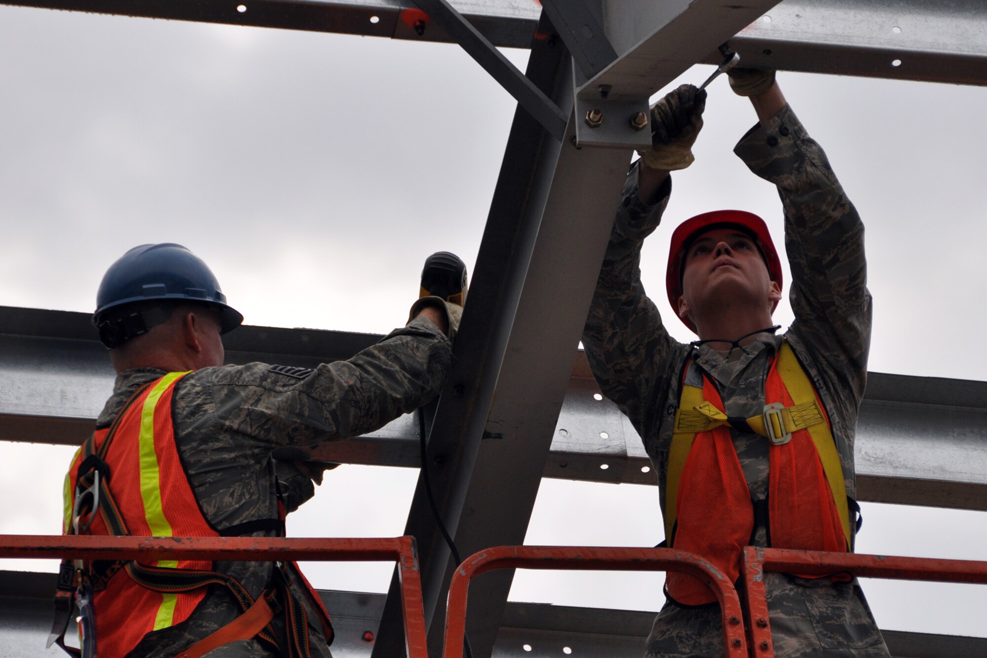 Tech. Sgt. Russell Kinnard, a heating, ventilation, air conditioning and refrigeration technician, and Airman 1st Class Zachary Chaney, an electrician, tighten fasteners during the construction of a Pre-Engineered building at Youngstown Air Reserve Station, Vienna, Ohio, Aug. 14, 2012. After tightening, the fasteners were marked with easily seen paint to signify they had been tightened. Both Airmen are assigned to the 307th Civil Engineer Squadron from Barksdale Air Force Base, La. They were part of a 29-person detail from Barksdale that spent two weeks at Youngstown ARS assisting 910th Civil Engineer Squadron personnel build a Prime Base Engineer Emergency Force (Prime BEEF) training area. (U.S. Air Force photo by Master Sgt. Jeff Walston)