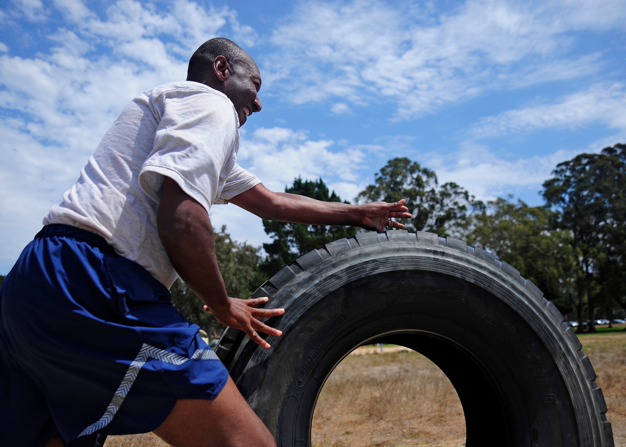 VANDENBERG AIR FORCE BASE, Calif. -- Lt. Col. Warren Watties, 30th Space Wing chaplain, competes in the tire push portion of a Chiefs vs. Eagles relay race challenge during sports day at Cocheo Park here Friday, August 17, 2012. Sports day is organized by the 30th Force Support Squadron Fitness Center staff and offers squadrons and organizational teams a chance to compete in a variety of sporting events throughout the day. The 30th Civil Engineer Squadron finished the competition with the first place championship. (U.S. Air Force photo/Michael Peterson)