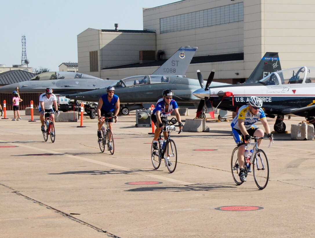 Hotter 'N Hell Hundred cyclists passing through Airpower Alley. All cyclists in this year’s race will get to pass through Airpower Alley and see many different Air Force Aircraft. (U.S. Air Force/Courtesy Photo)