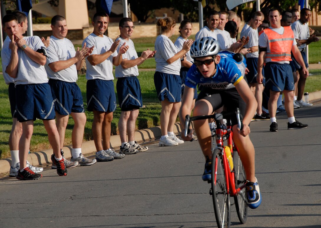 A Hotter 'N Hell Hundred cyclist gets cheered on as he passes through AiT (Airmen in Training) Alley. Hundreds of Airmen will be cheering on riders in this year's Hotter 'N Hell Hundred. (U.S. Air Force/Courtesy Photo)