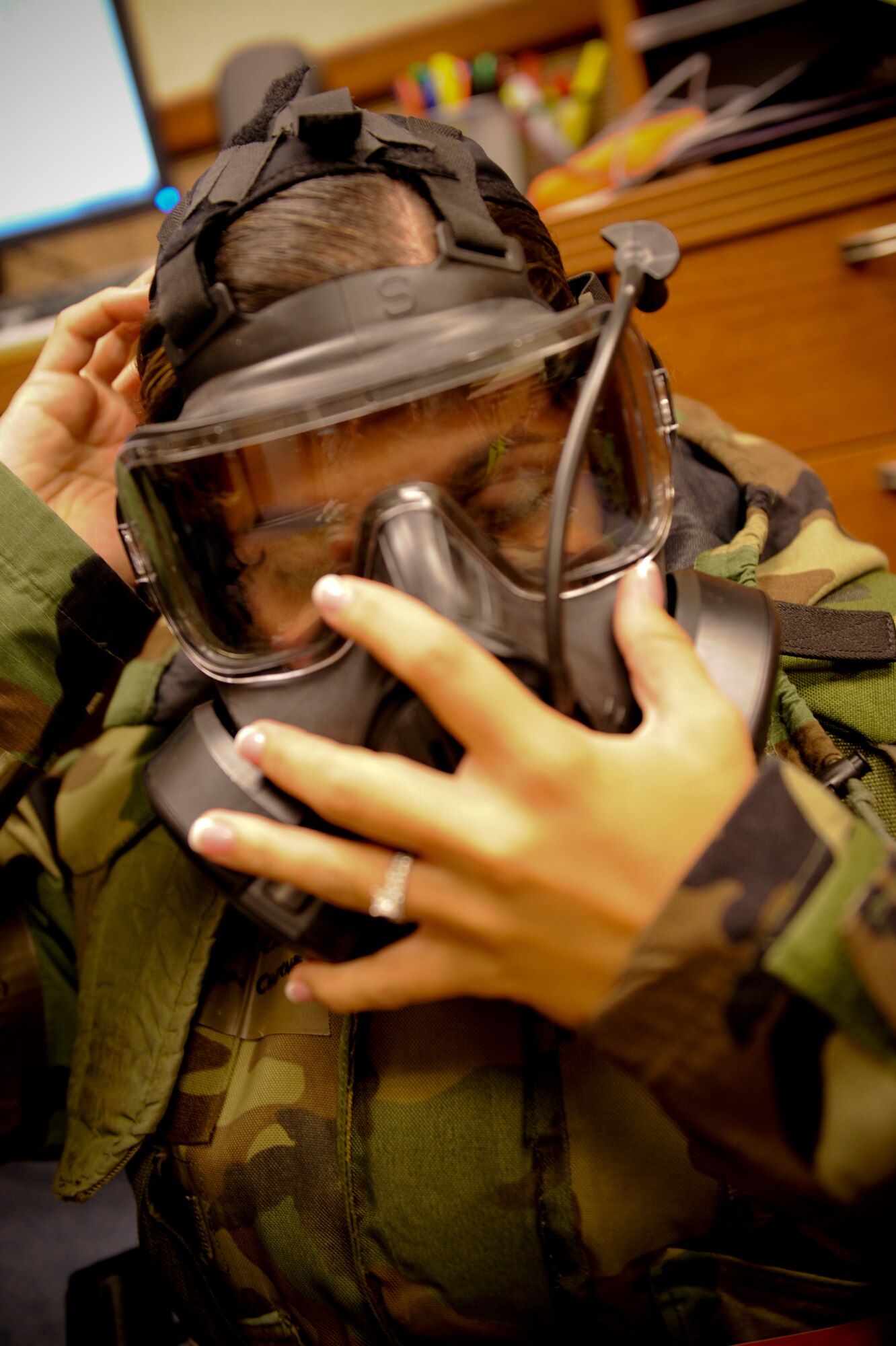 U.S. Air Force Capt. Natassia Cherne, 18th Wing Public Affairs deputy chief, puts on her gas mask when the base fell under attack during a local operational readiness exercise on Kadena Air Base, Japan, Aug. 22, 2012. LOREs subject the Shogun Warriors to a multitude of training tasks such as, following through with certain procedures during different alarm levels. (U.S. Air Force photo by Airman 1st Class Brooke P. Beers)