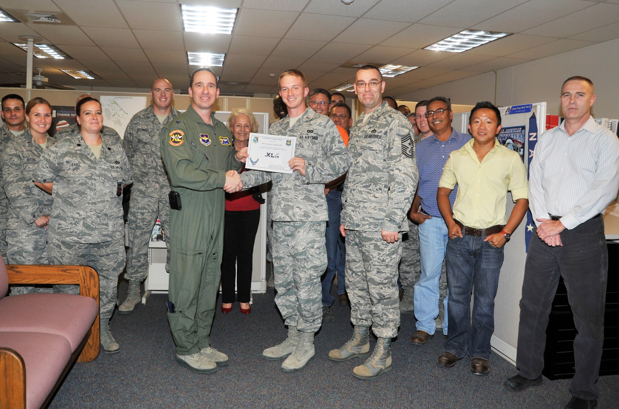 2nd Lt. Garrett Karnowski, 47th Civil Engineer Squadron project manager, poses with Col. Tom Murphy, 47th Flying Training Wing commander, and Chief Master Sgt. Garry Berry, 47th FTW command chief, after being presented the XLer of the week award at Laughlin Air Force Base, Texas, Aug. 1, 2012. The XLer is a weekly award chosen by wing leadership and given to those who consistently make outstanding contributions to Laughlin and their unit. (U.S. Air Force photo/Jose Mendoza)