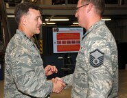 Lt. Gen. Burton Field, Air Force deputy Chief of Staff for Operations, Plans and Requirements, congratulates Master Sgt. Jeffrey Schlabs, 527th Space Aggressor Squadron, for earning the Enlisted Space Systems Operator of the Year award during the general's visit Aug. 21 at Schriever. The award is given annually to recognize exceptional performance by a senior NCO, NCO and Airman in the space systems operations career field. This award is given to one individual in each category who made the most significant contribution to space operations in the previous calendar year. (U.S. Air Force photo/Staff Sgt. Julius Delos Reyes)