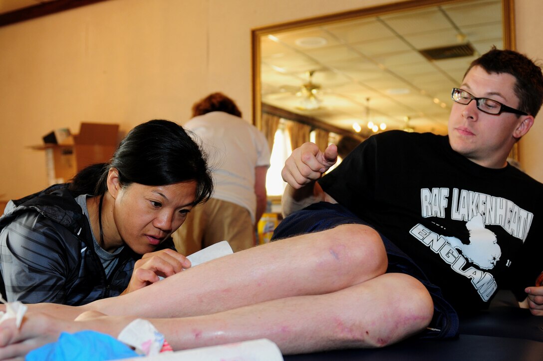 ROYAL AIR FORCE LAKENHEATH, England – Josh Roberts, U.S. Paralympian, is treated for a cut by Suzy Kim, U.S. Paralympic team doctor, Aug. 22, 2012. Roberts is competing in the 100m, 200m, 400m and 800m race. More than 50 U.S. Paralympians and hopefuls will be honing their skills and making final preparations here Aug. 18 through 25 for competition in the London 2012 Paralympic Games. (U.S. Air Force photo by Airman 1st Class Cory D. Payne)