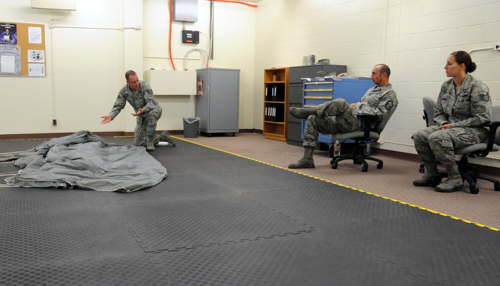 Staff Sgt. Aaron Call (left), 361st Training Squadron Aircrew Flight Equipment instructor, discusses the MC-4 parachute system with students Master Sgt. Dustin Ogburn (center) and Staff Sgt. Amber Engelhart (right) during RAM-AIR training Aug. 18, 2012 at Sheppard Air Force Base, Texas. The students earn one Community College of the Air Force credit hour for the week-long course.  (U.S. Air Force photo/Josh Wilson)