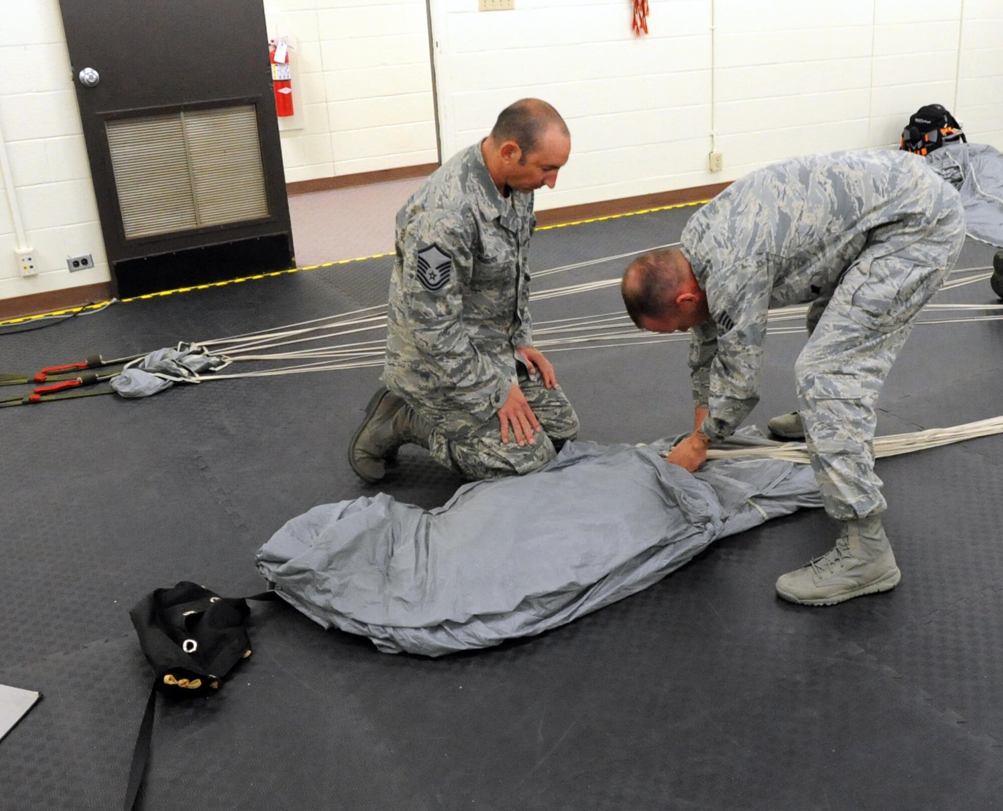 aster Sgt. Dustin Ogburn (left) watches Staff Sgt. Aaron Call, 361st Training Squadron Aircrew Flight Equipment instructor, demonstrates in-processing inspection procedures on the MC-4 parachute system during RAM-AIR training Aug. 18, 2012 at Sheppard Air Force Base, Texas.The 361st TRS conducts advanced parachute packing training for both static line and high altitude/low-opening type parachutes.  (U.S. Air Force photo/Josh Wilson)