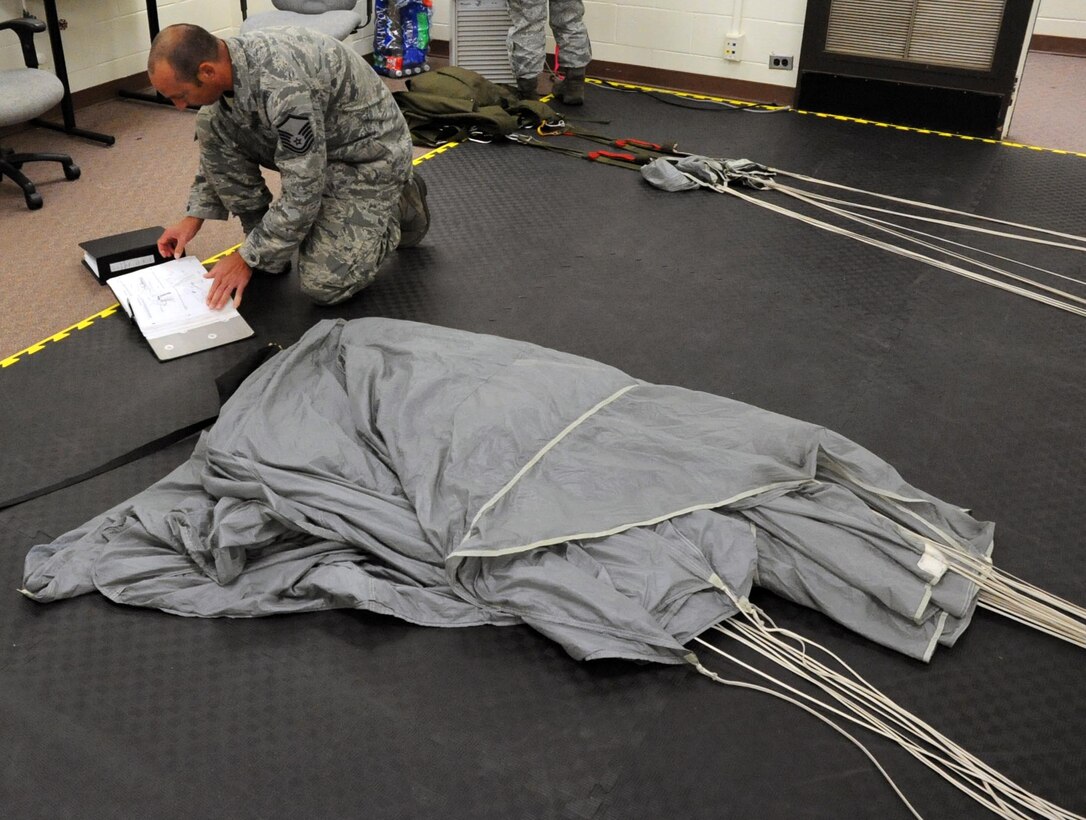 Master Sgt. Dustin Ogburn, 336th Training Support Squadron Aircrew Flight Equipment superintendent at Fairchild Air Force Base, Wash., reads technical data about the MC-4 parachute system during RAM-AIR training Aug. 18, 2012 at Sheppard Air Force Base, Texas. The MC-4 parachute is used by special operations type forces.  (U.S. Air Force photo/Josh Wilson)