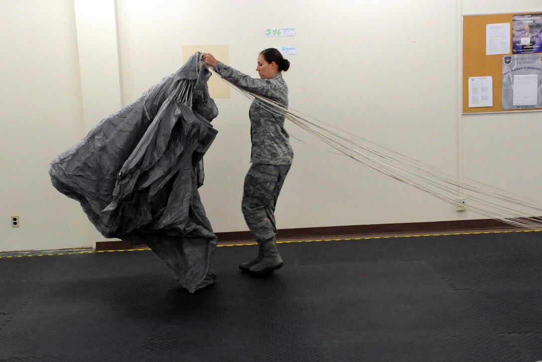 Staff Sgt. Amber Engelhart, Special Tactics Training Squadron aircrew flight equipment rigger at Hurlburt Field, Fla., inspects theMC-4 parachute system during RAM-AIR training Aug. 18, 2012 at Sheppard Air Force Base, Texas. Engelhart is receiving advanced parachute packing training for supervisors from the 361st Training Squadron.  (U.S. Air Force photo/Josh Wilson)