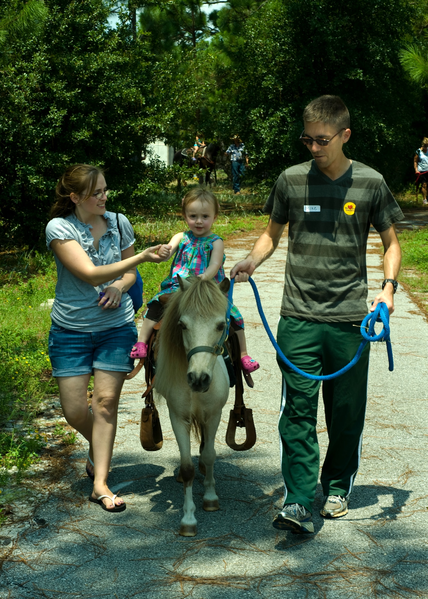 Renee Havron, left, wife of Staff Sgt. Joshua Havron, 1st Special Operations Communications Squadron, holds on to her daughter, Lily, 2, as she rides a pony, Bucky, led by Staff Sgt. Michael Larson, a weather forecaster from 1st Special Operations Support Squadron and event volunteer, during the Commando Agencies Reaching Everyone carnival at the Community Park at Hurlburt Field, Fla., Aug. 18, 2012. Lily was one of hundreds of children who had the opportunity to ride a horse at the event. (U.S. Air Force photo by Airman 1st Class Nigel Sandridge)