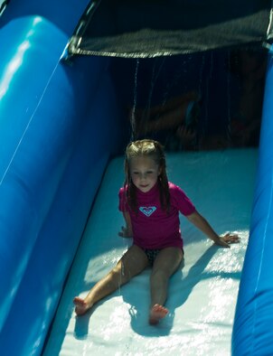 Emily Raffield, 7, daughter of Master Sgt. Jennifer Raffield, 1st Special Operations Wing Judge Advocate, and Tech. Sgt. Michael Raffield, 823rd RED HORSE, plays on a water slide during the Commando Agencies Reaching Everyone carnival at the Community Park on Hurlburt Field, Fla., Aug. 18, 2012. Volunteers manned the slide as well as other rides and information booths at the event. (U.S. Air Force photo by Airman 1st Class Nigel Sandridge)