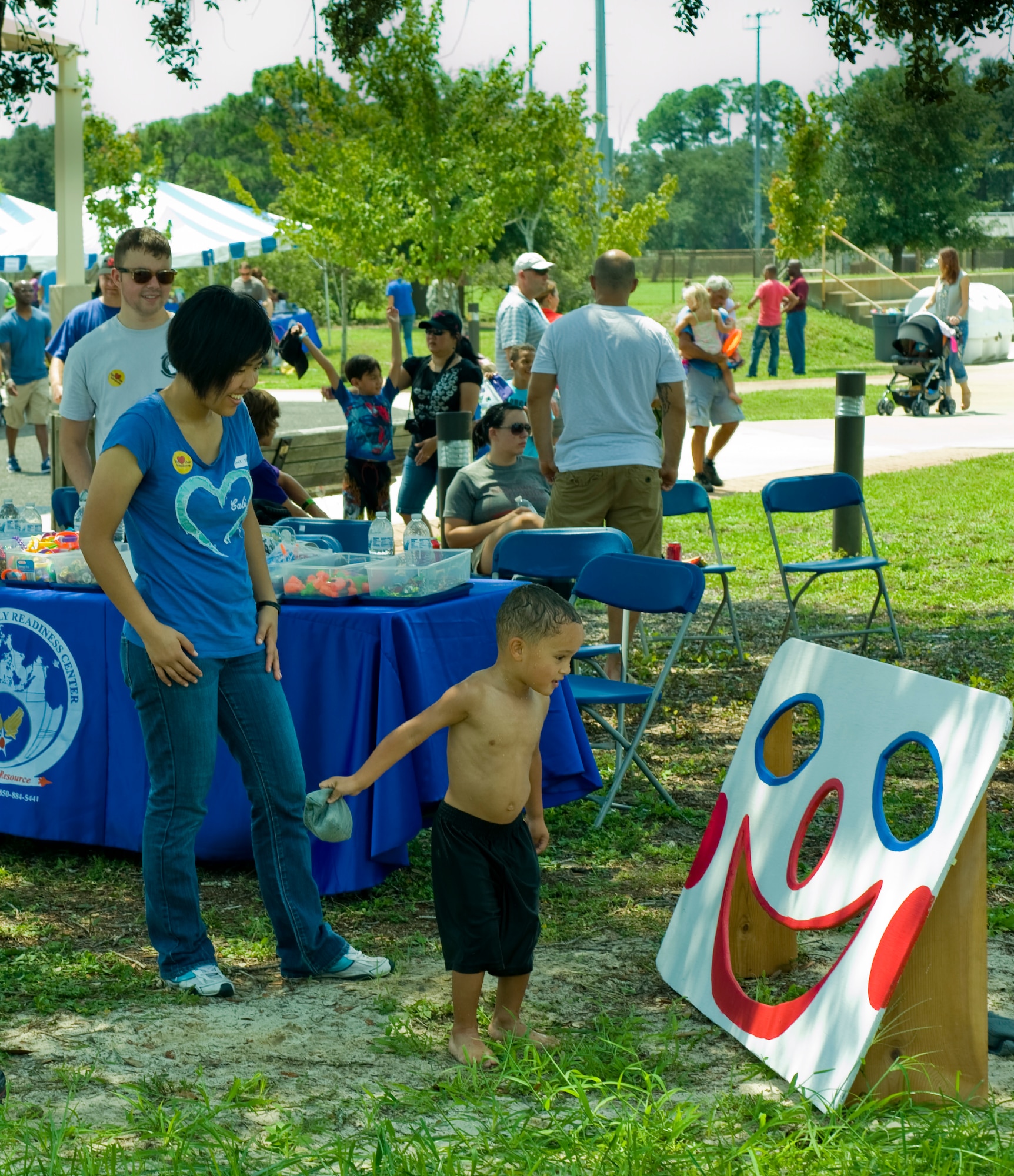 Riley Kasberg, three-year-old son of Senior Airman Eric Kasberg, a services journeyman of 1st Special Operations Force Support Squadron, prepares to throw a bean bag as Airman 1st Class Grace Eng, a communications and navigation technician from 1st Special Operations Aircraft Maintenance Squadron, looks on during the Commando Agencies Reaching Everyone carnival at the Community Park on Hurlburt Field, Fla., Aug. 18, 2012. Eng is one of many volunteers who helped at the carnival. (U.S. Air Force photo by Airman 1st Class Nigel Sandridge)