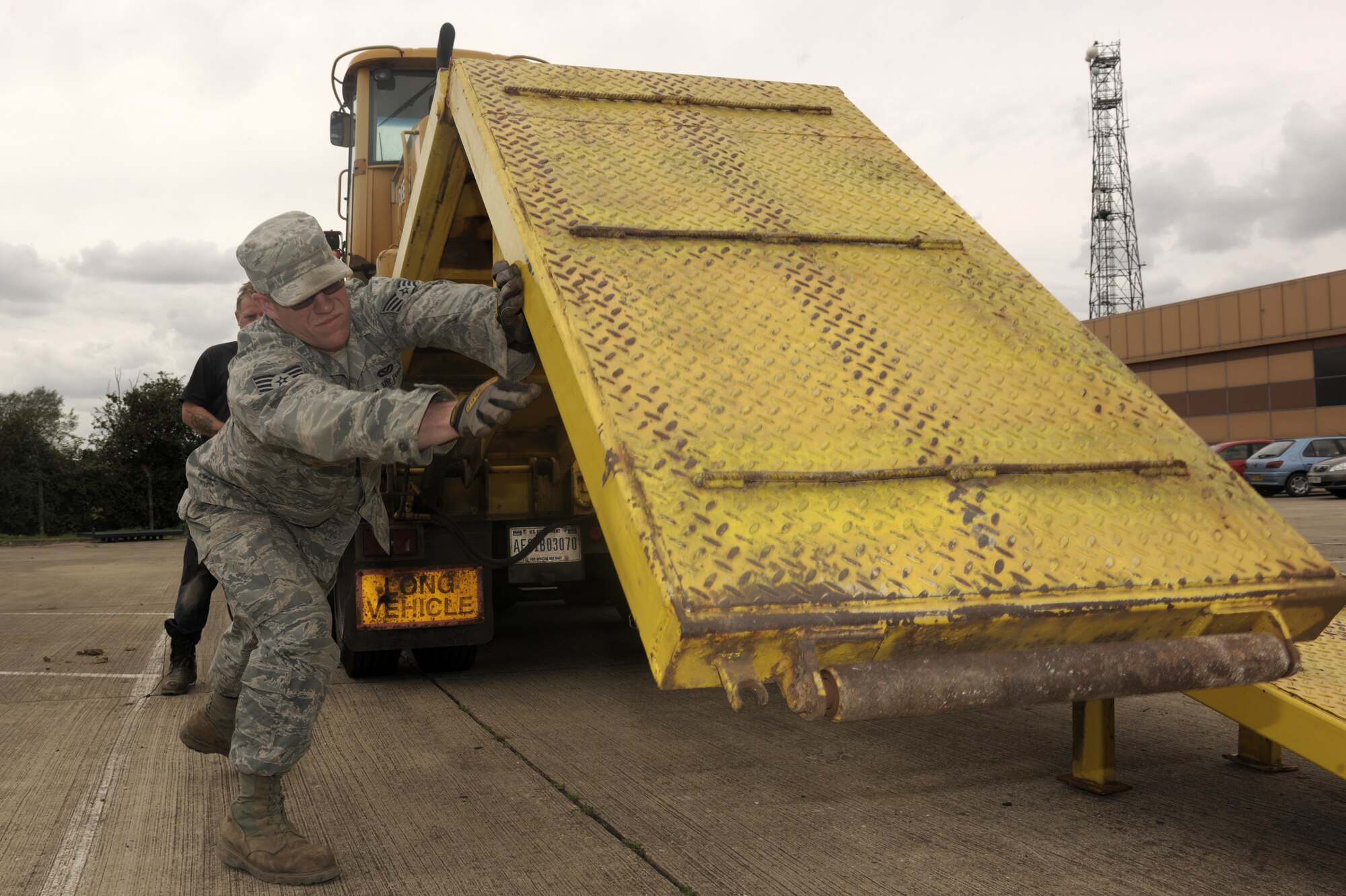 RAF ALCONBURY, United Kingdom - Staff Sgt. Adam Rouse, 423rd Civil Engineer Squadron, drops the ramps of a tractor-trailer Aug. 21 on RAF Alconbury. He lowered the ramps so he could unload a front-end loader from a tractor-trailer. (U.S. Air Force photo by Master Sgt. John Barton)