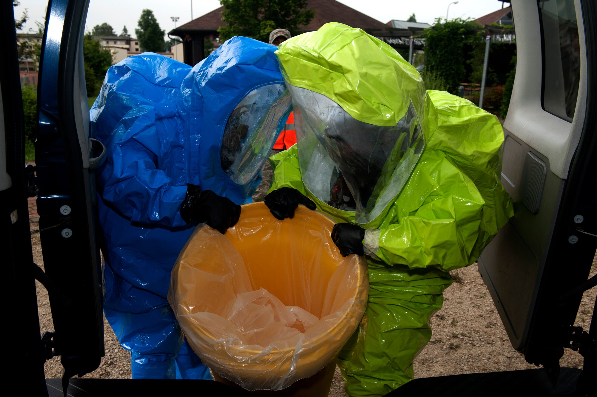 SPANGDAHLEM AIR BASE, Germany – Staff Sgt. Henry Lux, left, 52nd Aerospace Medicine Squadron bioenvironmental engineering technician, and Senior Airman Ashley Charfauros, 52nd Civil Engineer Squadron emergency management technician, quarantine a simulated leaking container after a simulated explosion during a base exercise here Aug. 21.  Exercises like this test the technical skills and efficiency of first responders and emergency management procedures base-wide to strengthen the development of common tactics and techniques in preparation for real-world events. (U.S. Air Force photo by Airman 1st Class Gustavo Castillo/Released)