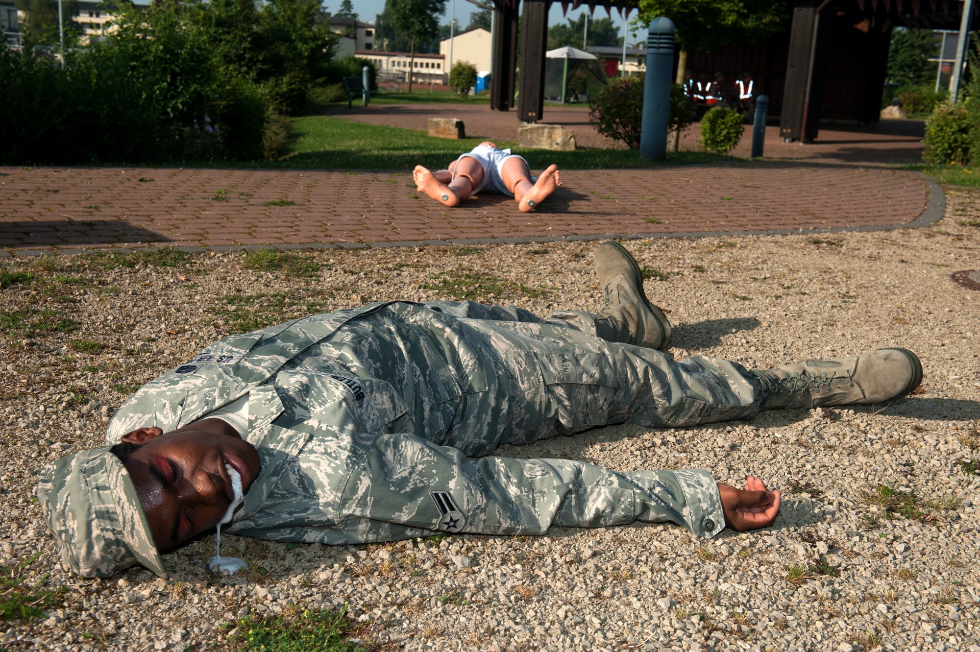 SPANGDAHLEM AIR BASE, Germany – Airman 1st Class Geon Butler, 52nd Communications Squadron radio frequency transmissions technician, plays dead after a simulated explosion during a base exercise here Aug. 21.  Exercises like this test the technical skills and efficiency of first responders and emergency management procedures base-wide to strengthen the development of common tactics and techniques in preparation for real-world events. (U.S. Air Force photo by Airman 1st Class Gustavo Castillo/Released)