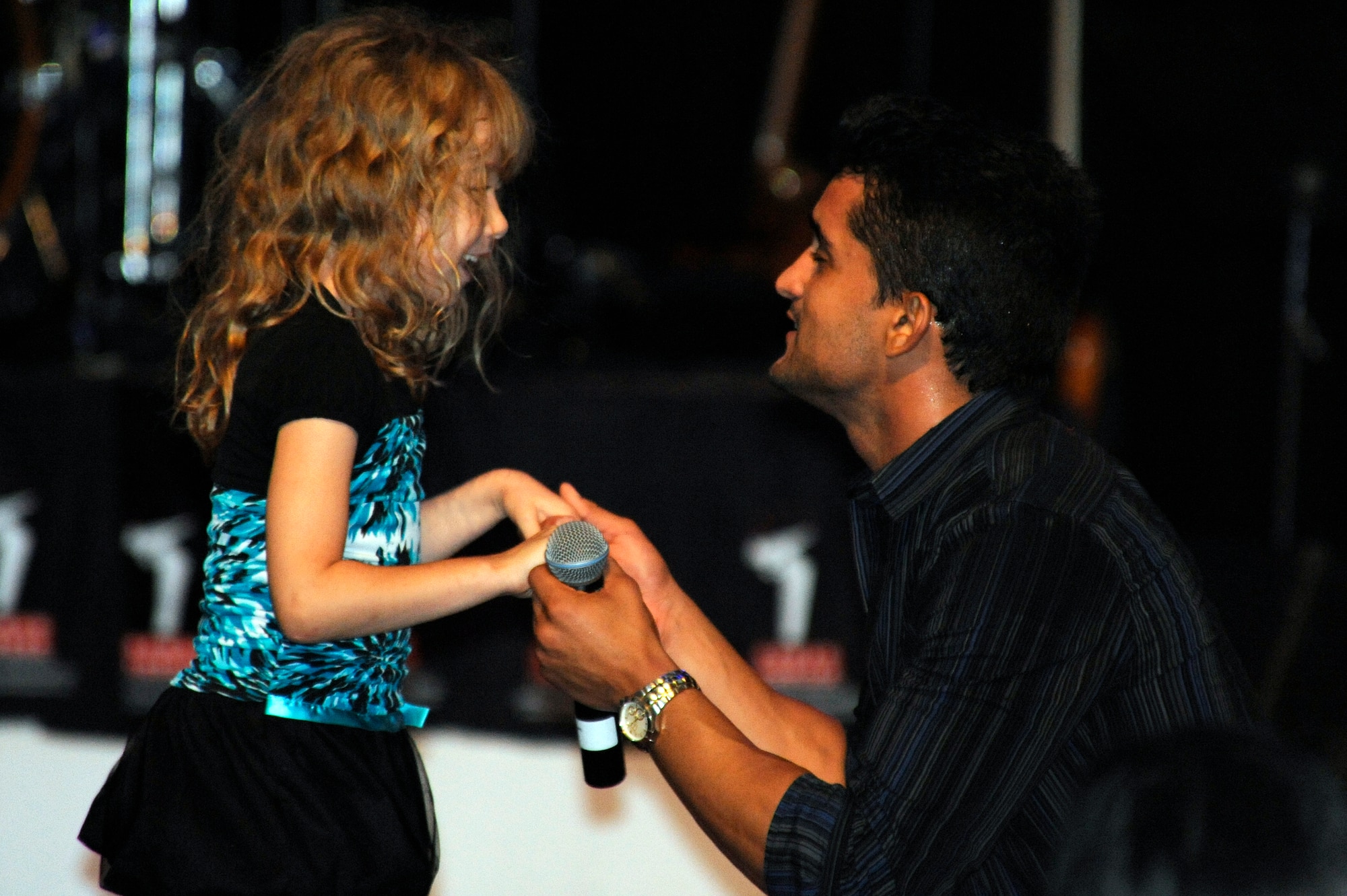 Jovany Javier, American Idol season 10 contestant, sings to a child during Idols World Tour concert at the Misawa Civic Center in Misawa City, Japan, Aug. 21, 2012. Armed Forces Entertainment brought the American Idol contestants to Misawa to show their support and to perform for military members and their families. (U.S. Air Force photo by Tech. Sgt. Marie Brown)
