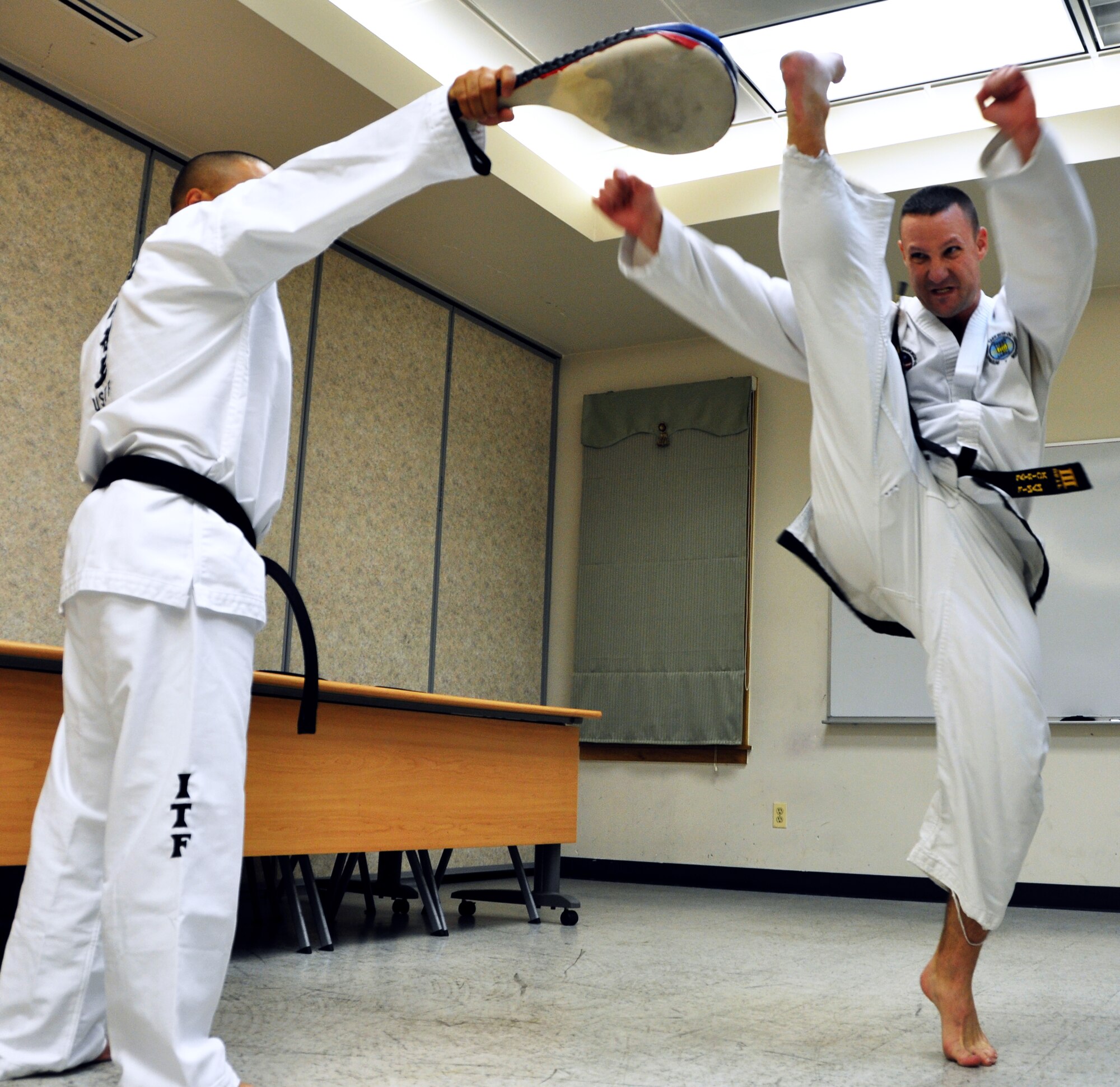 Lt. Col. Patrick Finan practices his kicks with Tech. Sgt. John Villanueva during kicking warm-ups at the Osan Air Base, Republic of Korea Community Center, Aug. 16, 2012. Finan has trained for more than 22 years in Taekwon-Do, and is the Armed Forces Director of the United States Taekwon-Do Federation along with the 7th Air Force Inspector General. Finan holds free Taekwon-Do classes Tuesday’s and Thursdays from 7 p.m. to 9 p.m. for anyone who wants to participate. Villanueva is a 7th Air Force medical material apprentice. (U.S. Air Force photo/Staff Sgt. Stefanie Torres)