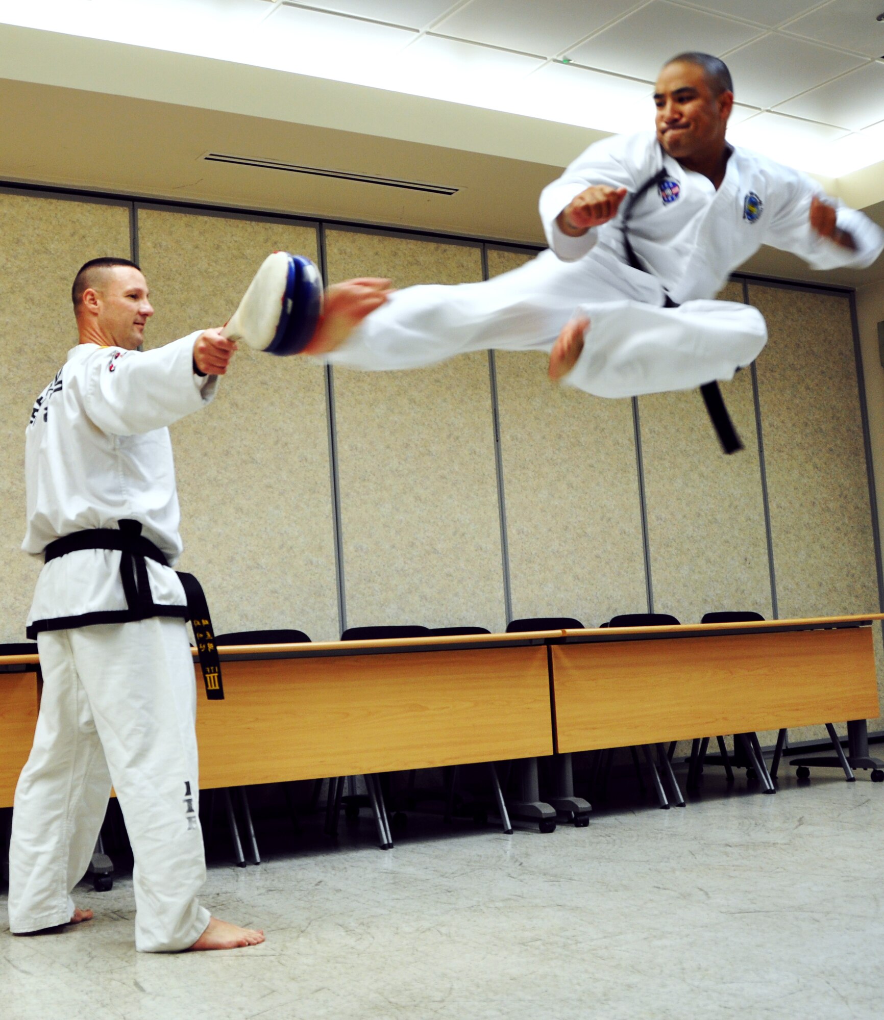 Lt. Col. Patrick Finan watches Tech. Sgt. John Villanueva’s form during kicking warm-ups at the Osan Air Base, Republic of Korea Community Center, Aug. 16, 2012. Finan holds free Taekwon-Do classes Tuesday’s and Thursdays from 7 p.m. to 9 p.m. for anyone who wants to participate. Finan is a 7th Air Force Inspector General and Armed Forces Director of the United States Taekwon-Do Federation. Villanueva is a 7th Air Force medical material apprentice. (U.S. Air Force photo/Staff Sgt. Stefanie Torres)