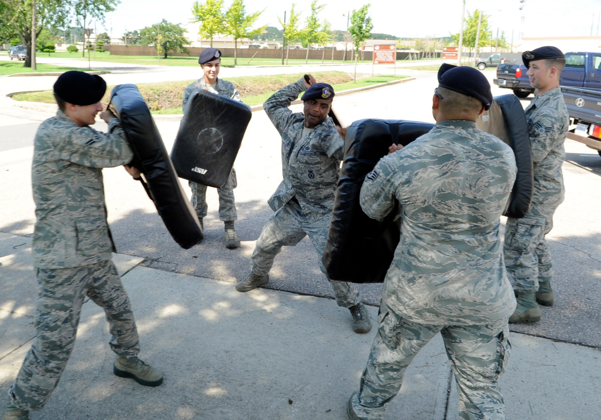 Staff Sgt. Frank Simpson, center, 8th Security Forces Squadron security forces trainer, demonstrates how to fend off multiple attackers with an expandable baton during training at Kunsan Air Base, Republic of Korea, Aug. 17, 2012. Kunsan security forces members also use other “less than lethal” techniques including Tasers and rifle butt strokes to control aggressive but non-lethal situations. (U.S. Air Force photo/Senior Airman Brigitte N. Brantley)