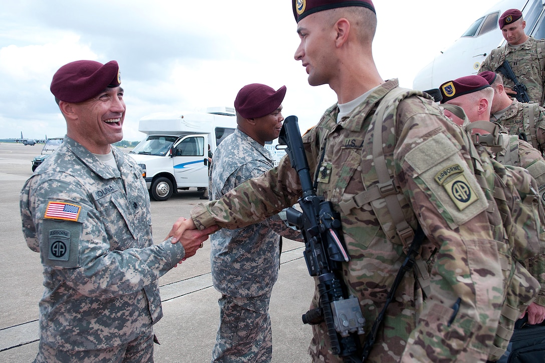 Army Lt. Col. Phillip Sounia, left, greets Army 1st Sgt. Kevin Engler ...