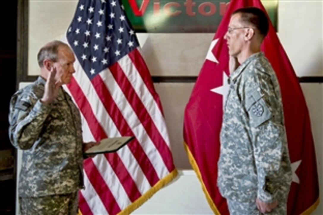 U.S. Army Gen. Martin E. Dempsey, chairman of the Joint Chiefs of Staff, conducts a re-enlistment ceremony for U.S. Army Staff Sgt. James Kelly on Bagram Airfield in Afghanistan, Aug. 21, 2012.