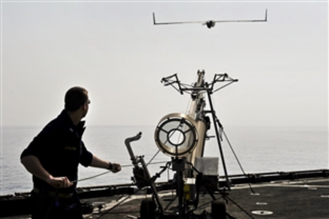 U.S. Navy Lt. Jeremy McCullough launches a Scan Eagle unmanned aerial vehicle from the flight deck of the amphibious dock-landing ship USS Gunston Hall in the Arabian Sea, Aug. 18, 2012. The Scan Eagle is a long-endurance, unmanned system that provides multiple surveillance, reconnaissance data, and battlefield damage assessment missions. McCullough  is a medical officer aboard the ship.