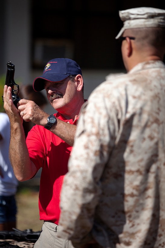 Former U.S. Marine Sgt. Randy Shierman (left), a Vietnam veteran who served with Golf Company, 2nd Battalion, 3rd Marine Regiment, examines an M9 service pistol under the watch of Gunner and Chief Warrant Officer 3 James Law, the 3rd Marine Regiment gunner, during a visit to Marine Corps Base Hawaii, Aug. 22, 2012. Nearly half a century since they fought through hell in Vietnam, approximately 30 former 2/3 Marines and their families visited the base to reminisce on their service and render honor to a brother lost in combat, Sgt. Maj. Wayne Hayes. Hayes was killed in action, Feb. 28, 1967, during Operation Prairie II while serving with many of the 2/3 veterans.