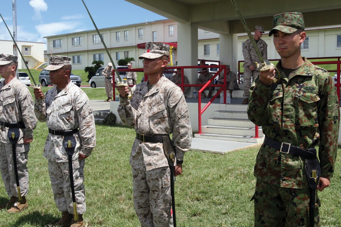 Sgt. Hironobu Ehara, right, executes the present sword movement at the Camp Foster parade deck Aug. 20 during practical application of the sword manual. Ehara is an infantryman with the Japan Ground Self-Defense Force’s 1st Division Headquarters and is currently a student at the Headquarters and Service Battalion’s corporals course.
