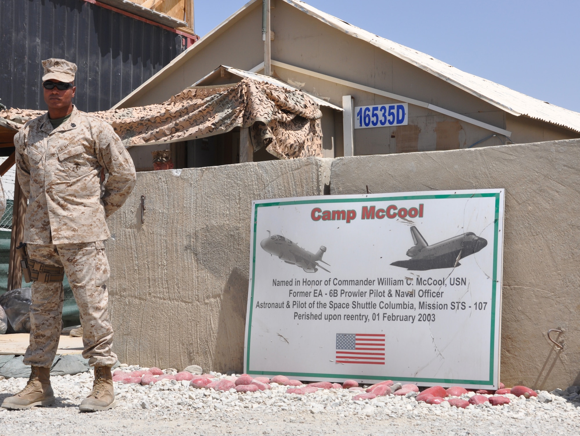 Sgt. Maj. Adam Moore, sergeant major of the Marine Tactical Electronic Warfare Squadron-2, stands ceremonial watch beside his camp's dedication sign at Camp McCool's closing ceremony on Bagram Airfield, Afghanistan, Aug. 8, 2012. The ceremony reminded Camp McCool's final residents of its brief-but-important nine-year history. The camp was the site of an insurgent attack on Bagram in 2009. The camp was named in honor of U.S. Navy Commander William C. McCool, fellow EA-6B Prowler pilot, and pilot of the Space Shuttle Columbia's ill-fated STS-107, which broke up during its return to Earth in February 2003. (U.S. Air Force photo/TSgt Shawn McCowan)