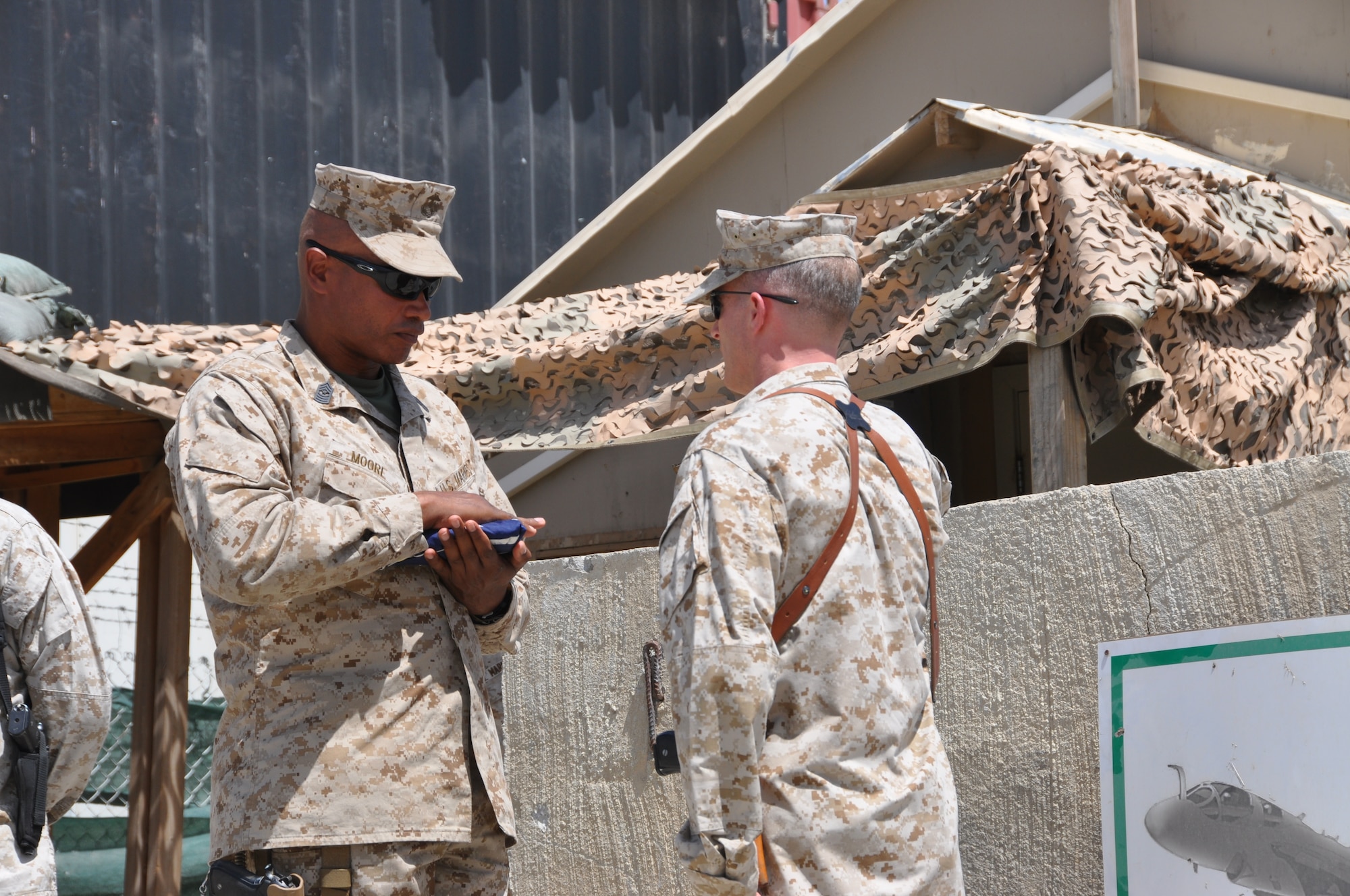 Lt. Col. Adam Musoff (right), unit commander, and Sgt. Maj. Adam Moore, sergeant major, of the Marine Tactical Electronic Warfare Squadron-2 honor their unit's American Flag at the end of Camp McCool's closing ceremony at Bagram Airfield, Afghanistan, Aug. 8, 2012. The ceremony reminded Camp McCool's final residents of its brief-but-important nine-year history. The camp was the site of an insurgent attack on Bagram in 2009. The camp was named in honor of U.S. Navy Commander William C. McCool, fellow EA-6B Prowler pilot, and pilot of the Space Shuttle Columbia's ill-fated STS-107, which broke up during its return to Earth in February 2003. (U.S. Air Force photo/TSgt Shawn McCowan)