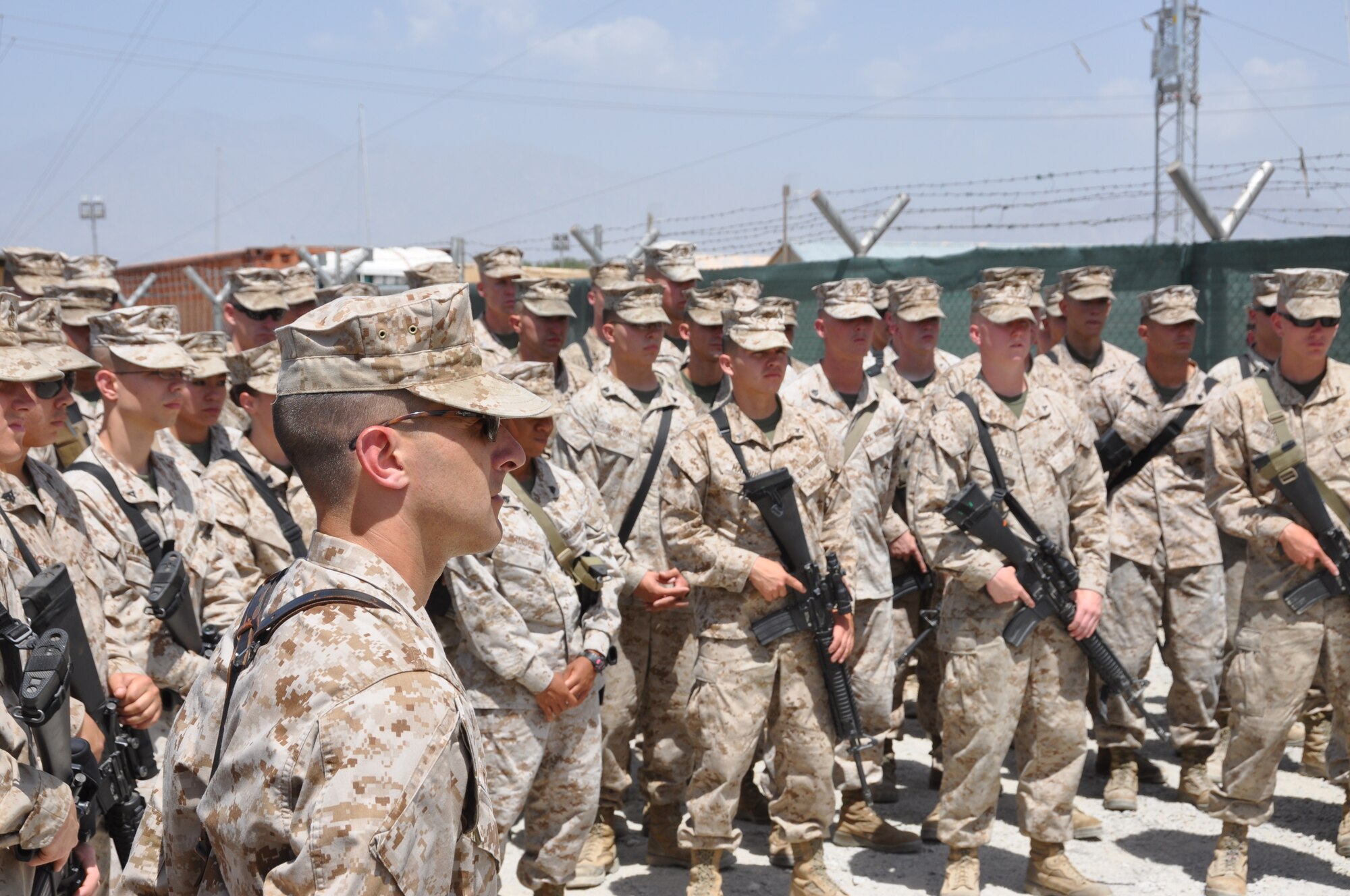 Members of the Marine Tactical Electronic Warfare Squadron-2 pause to hear their commander, Lt. Col. Adam Musoff, remind Camp McCool's final residents of its brief-but-important nine-year history during the camp's closing ceremony at Bagram Airfield, Afghanistan, Aug. 8, 2012. The camp was the site of an insurgent attack on Bagram in 2009. The camp was named in honor of U.S. Navy Commander William C. McCool, fellow EA-6B Prowler pilot, and pilot of the Space Shuttle Columbia's ill-fated STS-107, which broke up during its return to Earth in February 2003. (U.S. Air Force photo/TSgt Shawn McCowan)